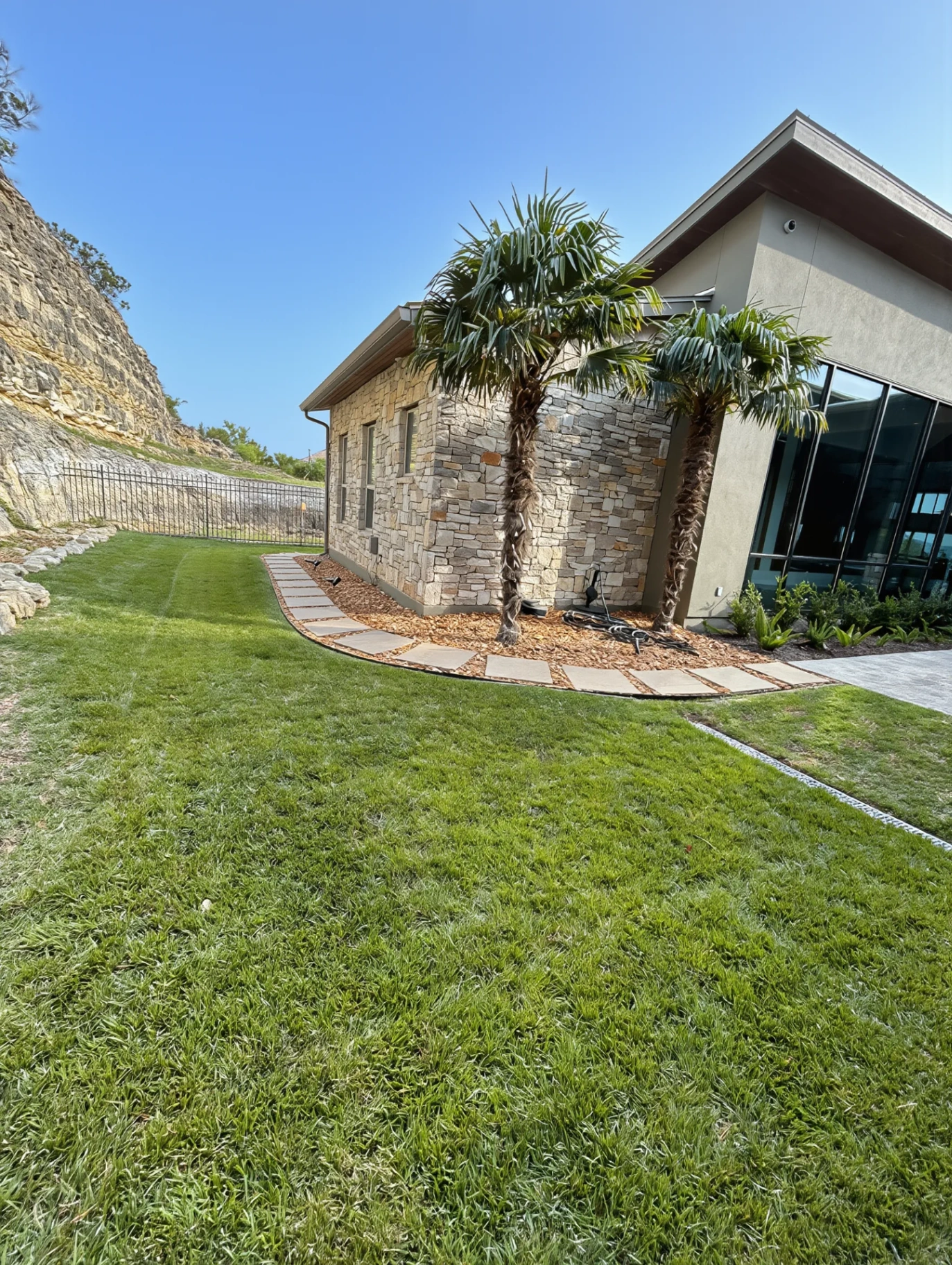 Modern cliff-stone home with crisp lawn edging