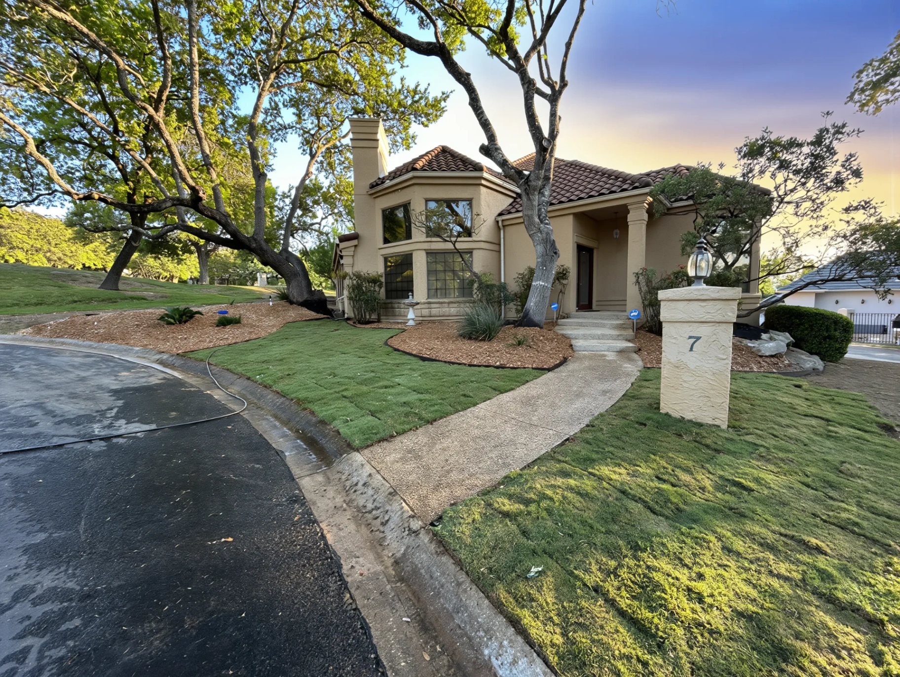 Dusk frontage with stone address pillar marked '7'