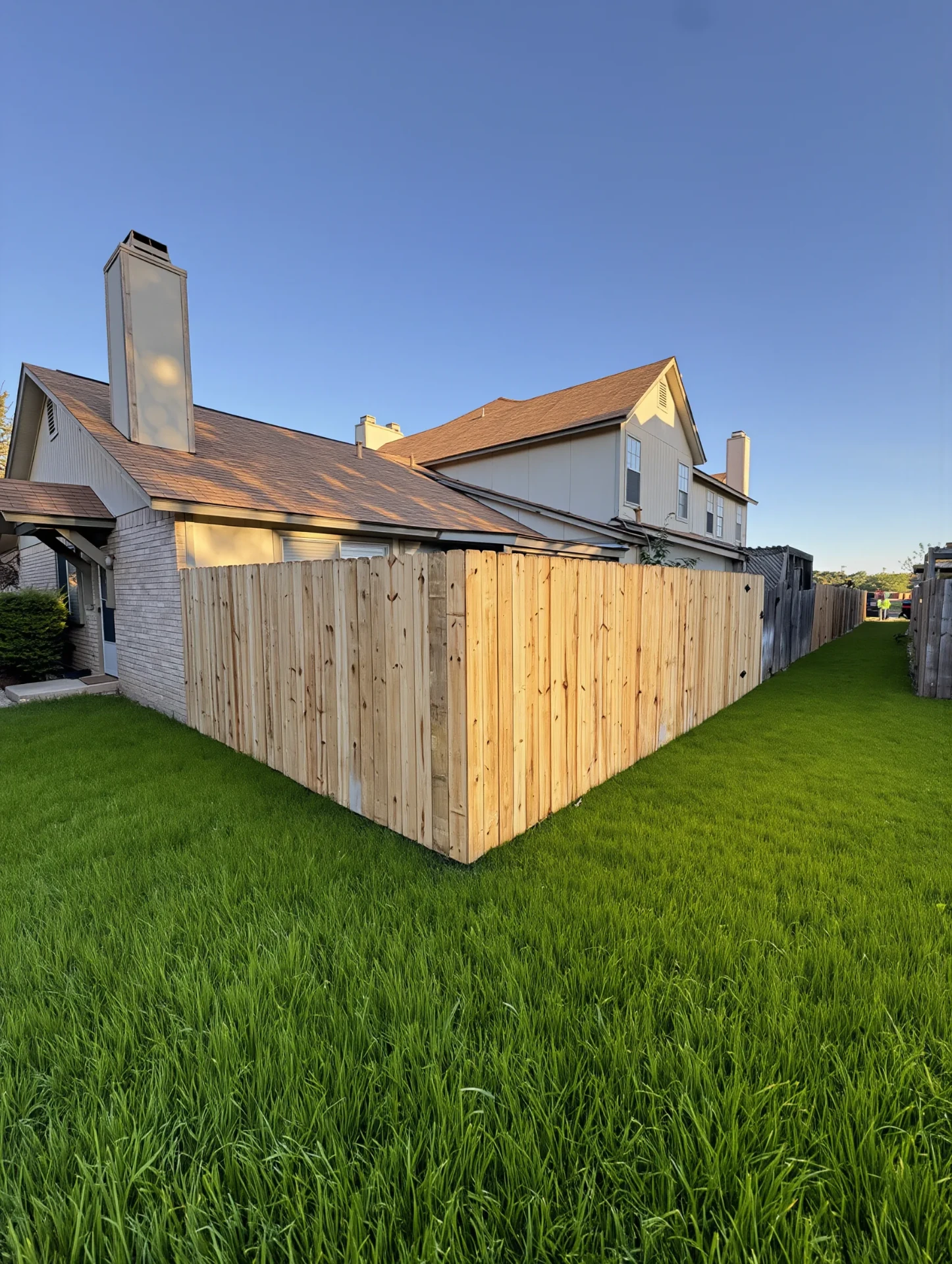 New cedar privacy fence framing a fresh back lawn